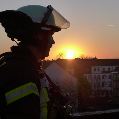 Bild vergrößern: Feuerwehrmann bei Sonnenuntergang