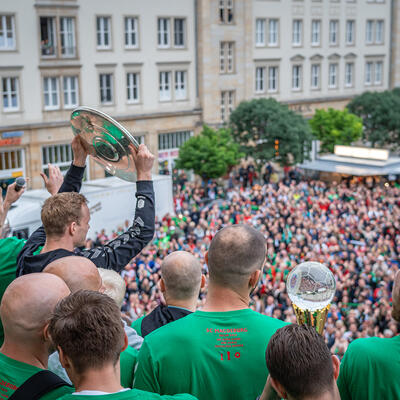 Hunderte Fans jubeln den SC Magdeburg Handballern auf dem Rathaus-Balkon zu