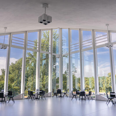 Blick durch die Glasfront der Hyparschale in den Stadtpark