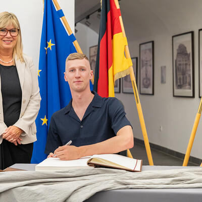 Florian Wellbrock trägt sich ins Goldene Buch der Landeshauptstadt ein.