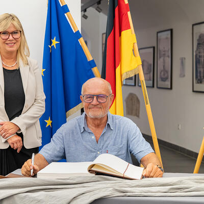 Norbert Warnatzsch trägt sich ins Goldene Buch ein.